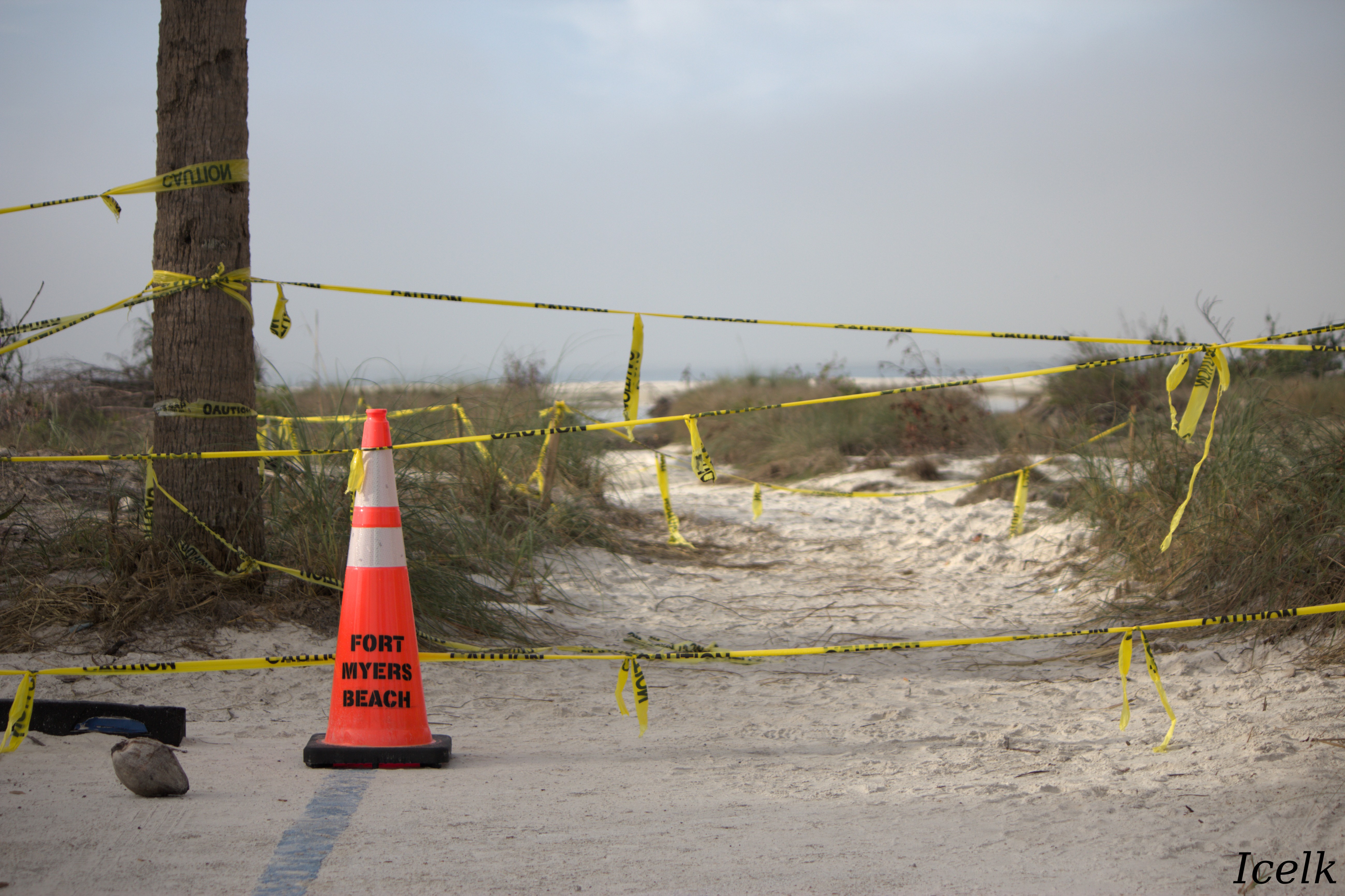 warning cone and causion tape across the entrance to the beach